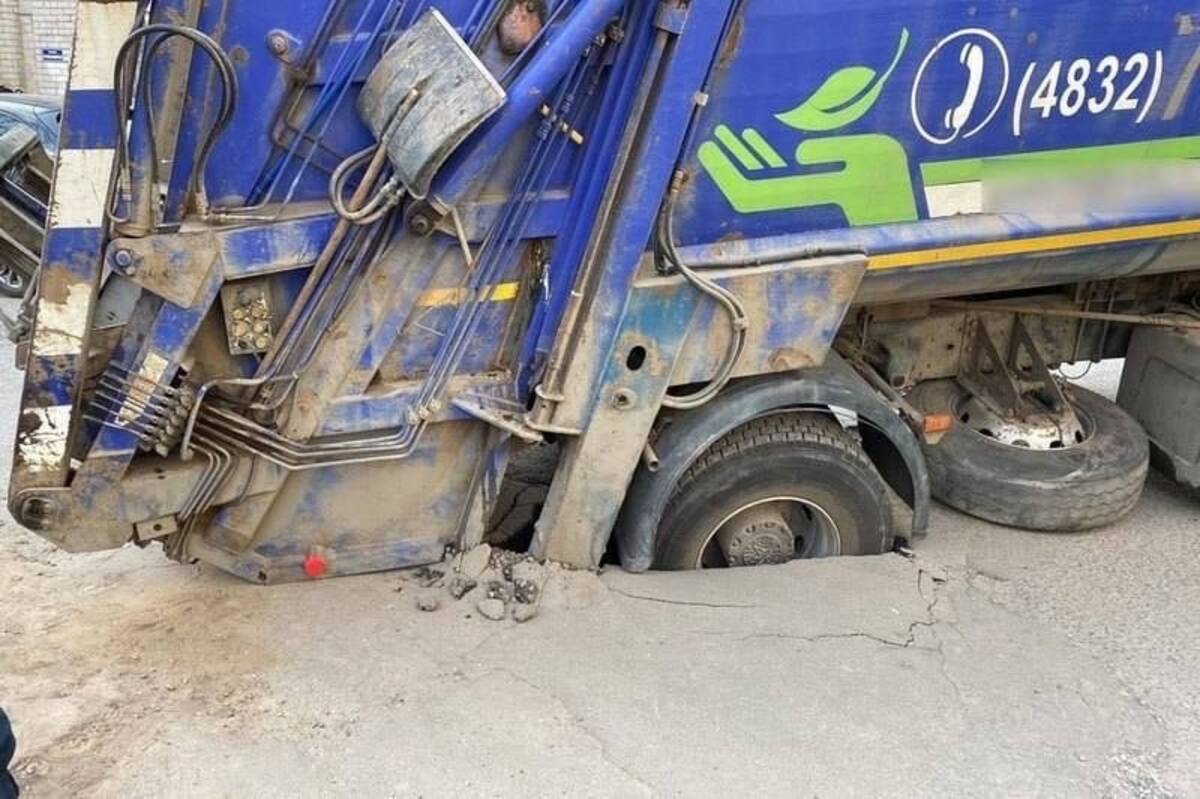 На улице Ромашина в городе Брянске мусоровоз попал в огромную яму на дороге